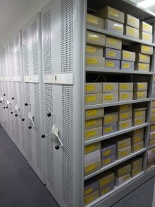 Archivboxen mit gelber Beschilderung im Rollregal