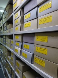 Archivboxen mit gelber Beschilderung im Rollregal